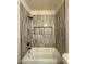 Modern bathroom with tub and shower, gray tile surround with built-in niche and black hardware at 1718 W Colter St # 142, Phoenix, AZ 85015