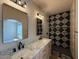 Modern bathroom featuring double sinks, a marble countertop, black fixtures and a black and white tile shower at 1718 W Colter St # 142, Phoenix, AZ 85015