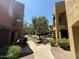 Exterior view of landscaped desert community with walkways, mature trees, and lush plantings at 1718 W Colter St # 142, Phoenix, AZ 85015