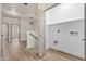 Hallway with wood-look floors leads to a laundry area and staircase with modern lighting fixture above at 1718 W Colter St # 142, Phoenix, AZ 85015
