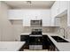 Clean kitchen showing white cabinets, dark countertops, stainless steel appliances, gray backsplash, and wood flooring at 1718 W Colter St # 142, Phoenix, AZ 85015