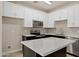 Modern kitchen featuring white cabinets, gray backsplash, stainless steel appliances, and a center island at 1718 W Colter St # 142, Phoenix, AZ 85015