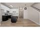 Open kitchen/living area featuring modern white cabinets, black appliances, center island, and staircase to the second level at 1718 W Colter St # 142, Phoenix, AZ 85015