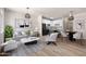 Modern living room showcases an open floorplan to kitchen, dining area, light gray sofa, wood floors, and stylish decor at 1718 W Colter St # 142, Phoenix, AZ 85015