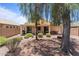 Spacious backyard with covered patio, rock landscaping, mature trees, and block fencing at 18066 W Weatherby Dr, Surprise, AZ 85374