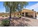 Expansive backyard featuring gravel landscaping, covered patio, and mature trees, creating a relaxing outdoor space at 18066 W Weatherby Dr, Surprise, AZ 85374
