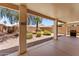 Covered patio overlooks xeriscaped backyard, with block wall fence, desert trees and gas grill at 18066 W Weatherby Dr, Surprise, AZ 85374