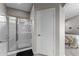 Bathroom showcases a shower with glass doors, a white door, and tile flooring at 18066 W Weatherby Dr, Surprise, AZ 85374
