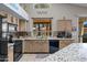 Bright kitchen with neutral cabinetry, black appliances, granite counter tops, and tile backsplash, perfect for cooking at 18066 W Weatherby Dr, Surprise, AZ 85374