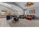 Open-concept living space with a cozy sectional couch, carpeted floors, and seamless flow to the kitchen and dining area at 18066 W Weatherby Dr, Surprise, AZ 85374