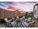 Outdoor seating area features stylish chairs around a fire pit, all set against a vibrant sunset at 19428 S 210Th Pl, Queen Creek, AZ 85142
