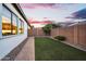 Exterior view of the backyard featuring artificial turf, a brick fence, and mature landscaping at 19428 S 210Th Pl, Queen Creek, AZ 85142