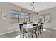 Elegant dining area with large windows, stylish light fixture, and seating for six at 19428 S 210Th Pl, Queen Creek, AZ 85142