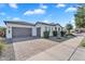 Stylish single-story home with a brick driveway, three-car garage, and desert landscaping at 19428 S 210Th Pl, Queen Creek, AZ 85142