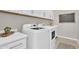Bright laundry room features white cabinetry, modern washer and dryer, and a convenient planning calendar at 19428 S 210Th Pl, Queen Creek, AZ 85142