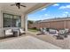 Covered patio with a seating area, overlooking the beautifully landscaped backyard at 19428 S 210Th Pl, Queen Creek, AZ 85142
