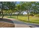 Scenic community walking path with mature trees and green lawn under a sunny sky at 19428 S 210Th Pl, Queen Creek, AZ 85142