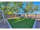 Backyard featuring artificial grass, surrounding landscaping, and a built in trampoline at 20139 N Bustos Way, Maricopa, AZ 85138