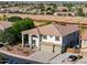A two-story home with a covered front porch and a three-car garage surrounded by desert landscaping at 20139 N Bustos Way, Maricopa, AZ 85138