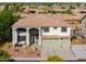 A two-story home featuring a covered front porch, a three-car garage, and desert landscaping at 20139 N Bustos Way, Maricopa, AZ 85138