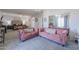 A bedroom with two pink sofas, a mirrored closet, and a large bed at 20139 N Bustos Way, Maricopa, AZ 85138