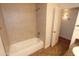 Bathroom featuring a white bathtub, tiled walls, and doorway to an adjoining room at 2025 E Campbell Ave # 120, Phoenix, AZ 85016
