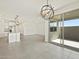 Open living space with light tile flooring, modern lighting, and access to an outdoor patio at 20795 N Roadrunner Ln, Maricopa, AZ 85138