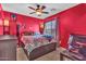 Bedroom featuring bright red walls, carpet, and a patterned comforter on the bed at 21050 E Munoz St, Queen Creek, AZ 85142