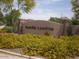 Entrance to Ocotillo Landing with stone pillars and vibrant yellow flowers at 21050 E Munoz St, Queen Creek, AZ 85142