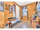 The foyer features vibrant orange walls, a decorative bench, and elegant tile flooring at 21050 E Munoz St, Queen Creek, AZ 85142