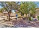 Charming single Gathering home, desert landscape, and lush mature trees in the front yard at 21050 E Munoz St, Queen Creek, AZ 85142