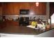 Kitchen with wood cabinets, black appliances, and a sink under a window at 21050 E Munoz St, Queen Creek, AZ 85142