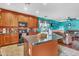 The kitchen features wooden cabinetry, a center island, and seamlessly flows into the living room at 21050 E Munoz St, Queen Creek, AZ 85142