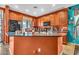 An open-concept kitchen features wooden cabinetry, a center island, and black appliances at 21050 E Munoz St, Queen Creek, AZ 85142