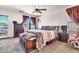 The main bedroom features a ceiling fan, neutral carpet, and a decorative bench at 21050 E Munoz St, Queen Creek, AZ 85142