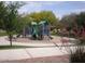 Outdoor playground featuring slides and climbing structures, surrounded by lush greenery and a well-maintained grassy area at 21050 E Munoz St, Queen Creek, AZ 85142