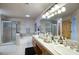 Bright bathroom featuring dual sinks, soaking tub, tiled floors, and glass enclosed shower at 235 W Portland St, Phoenix, AZ 85003