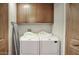 Convenient laundry room with front load washer and dryer and wooden cabinets at 235 W Portland St, Phoenix, AZ 85003