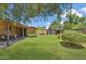 Spacious backyard featuring a covered patio, shed, lush lawn, and mature trees at 2913 E Earll Dr, Phoenix, AZ 85016