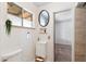 Bathroom featuring a modern sink and vanity, a round mirror and an open doorway at 2913 E Earll Dr, Phoenix, AZ 85016