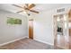 Bedroom features gray carpet, ceiling fan, window, and natural wood door at 2913 E Earll Dr, Phoenix, AZ 85016