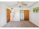 Bedroom features gray carpet, ceiling fan, closet, and natural wood door at 2913 E Earll Dr, Phoenix, AZ 85016