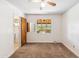 A well-lit bedroom with carpet flooring, a ceiling fan, and a window that provides views of the outside at 2913 E Earll Dr, Phoenix, AZ 85016