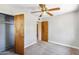Neutral bedroom features gray carpet, ceiling fan, closet, and natural wood door at 2913 E Earll Dr, Phoenix, AZ 85016