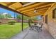 Covered patio with a dining table overlooking a well-maintained lawn at 2913 E Earll Dr, Phoenix, AZ 85016