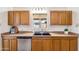 Functional kitchen featuring tiled flooring, oak cabinets, stainless steel dishwasher and sink at 2913 E Earll Dr, Phoenix, AZ 85016