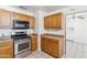Efficient kitchen featuring a stainless steel gas range, microwave and oak cabinets at 2913 E Earll Dr, Phoenix, AZ 85016