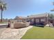 Expansive backyard with lush artificial grass, water feature, and outdoor kitchen at 30517 N Maple Chase Dr, San Tan Valley, AZ 85143