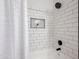 Close-up of a tiled shower and tub with a niche and black hardware and showerhead at 30517 N Maple Chase Dr, San Tan Valley, AZ 85143
