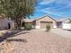 Single-story home with a low-maintenance rock yard, mature shade tree, and covered entrance at 30517 N Maple Chase Dr, San Tan Valley, AZ 85143